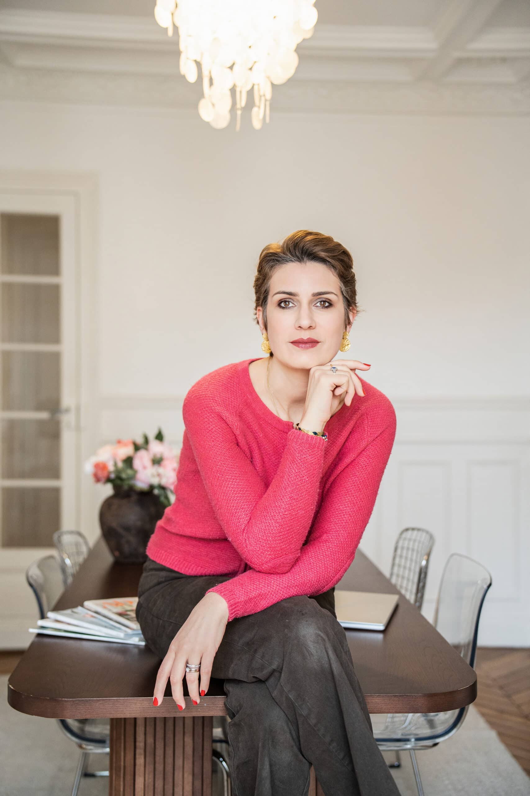Femme en pull rose assise dans un appartement parisien, séance branding – Sandra Da Silva, photographe Paris